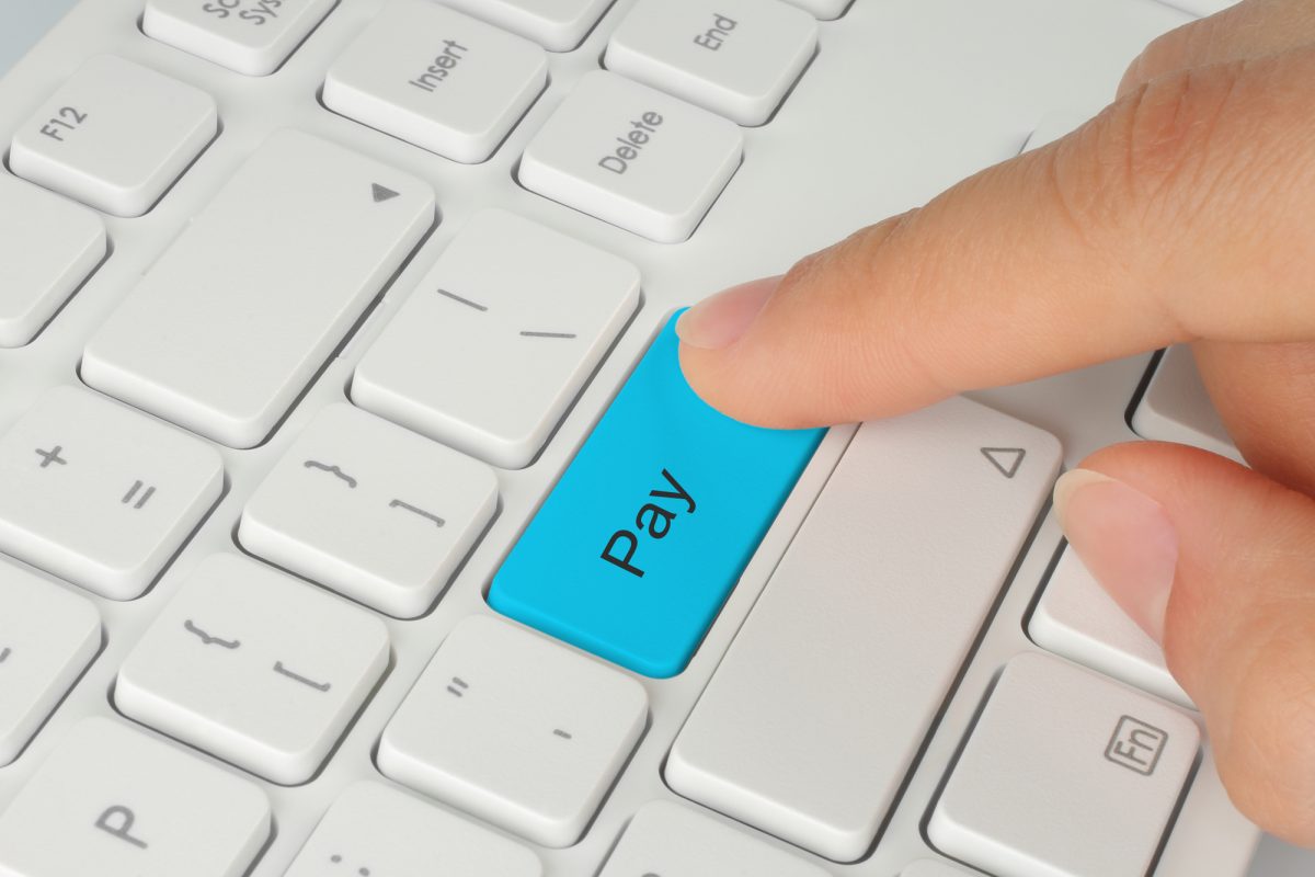 Hand pushing blue pay keyboard button